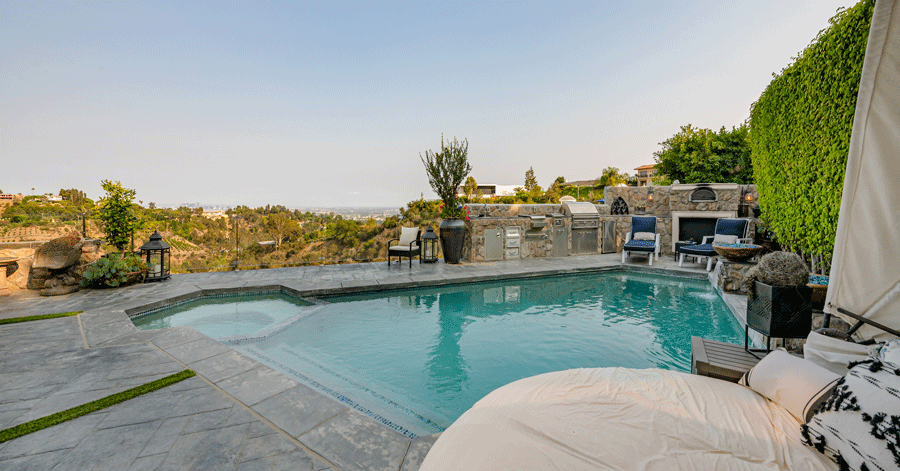 View of triangular shaped pool, spa, and canyon/city views